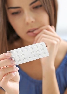 Eine Frau betrachtet eine Blisterpackung mit Tabletten in der Hand Fokus auf Medikament und Anwendung