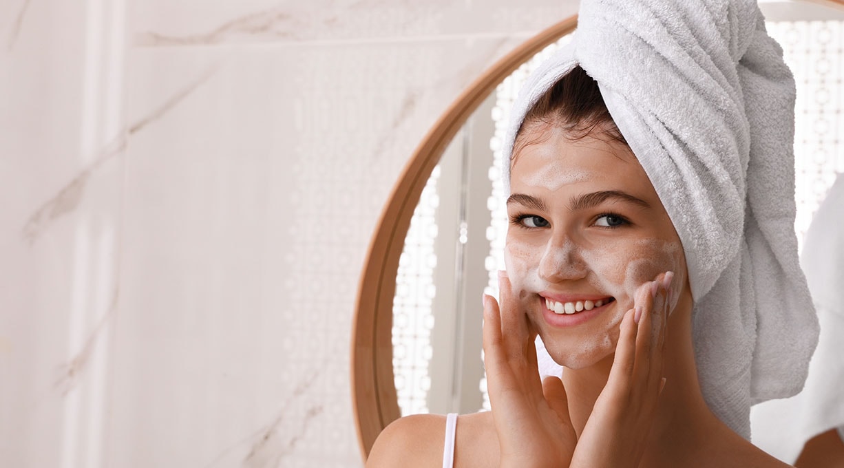 Eine junge Frau steht seitlich in der Sonne mit geschlossenen Augen