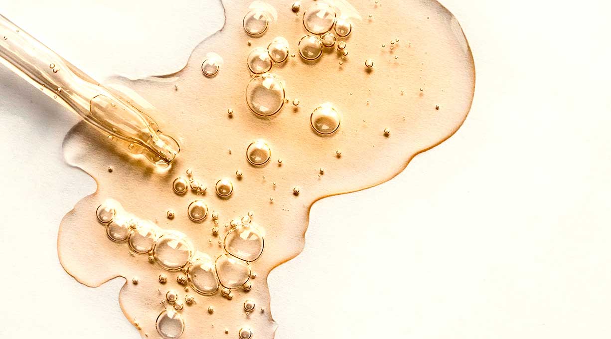 Pipette und Tropfen eines Serums gegen Erwachsenenakne mit Luftblasen