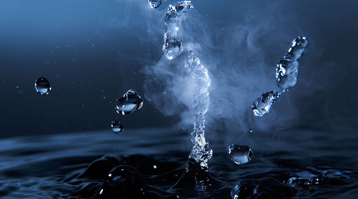 Tropfen von Thermalwasser fallen in dunkles Wasser