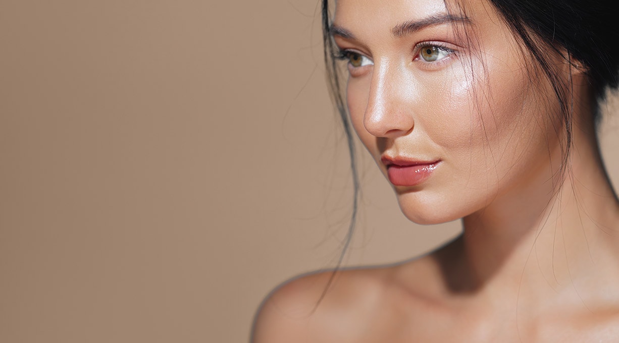 Junge Frau mit glatter Haut und natürlichem Glow steht für Hautpflege und Beauty