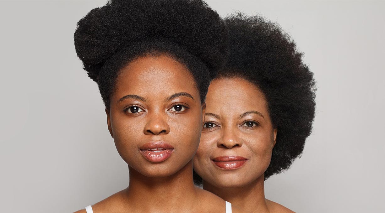 Porträtaufnahme von zwei Personen unterschiedlichen Alters mit direktem Blick in die Kamera