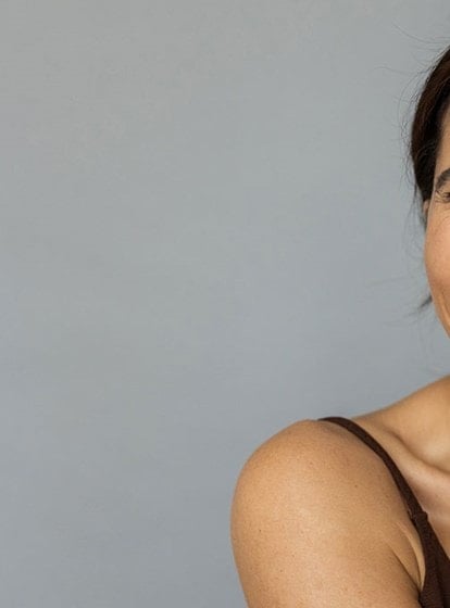 Schauspielerin Chyssanthi Kavazi trägt Gesichtspflege unter dem Auge auf und lächelt in die Kamera