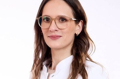 Frau Dr. Med. Schaaf ,eine Fachperson mit großer Brille und weißem Oberteil im Portrait für Beratungskontext.