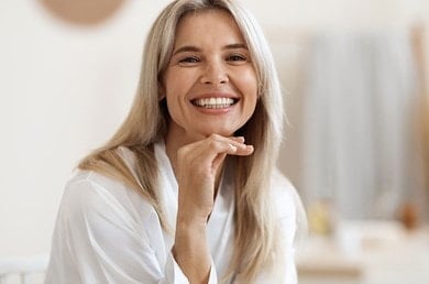 Frau im Bademantel nach Anwendung einer Hautpflege