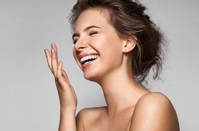 Eine junge gepflegte Frau mit braunen Haaren, die lacht