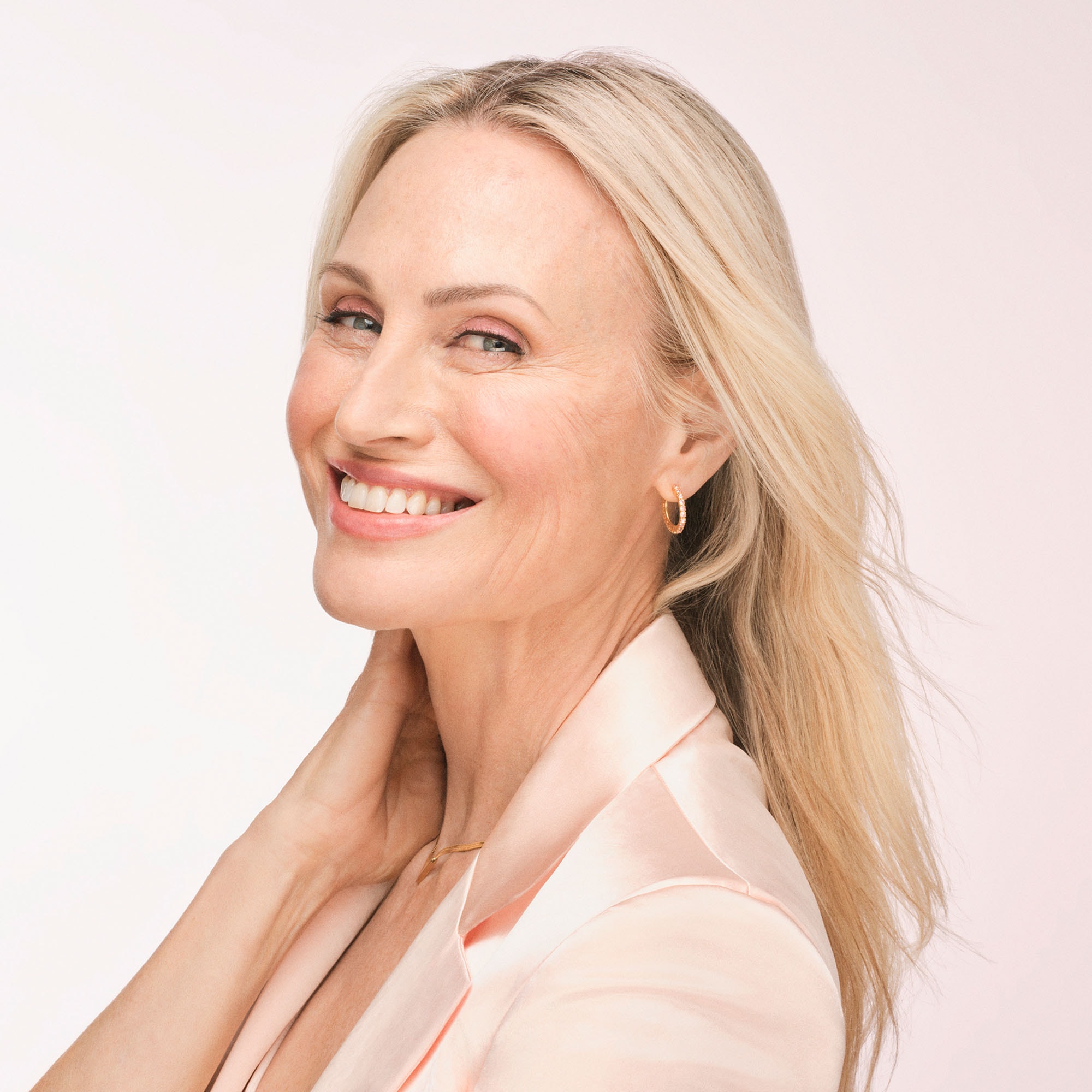 Blonde Frau mittleren Alters lächelt und zeigt Falten um den Mund, auf den Wangen und um die Augen