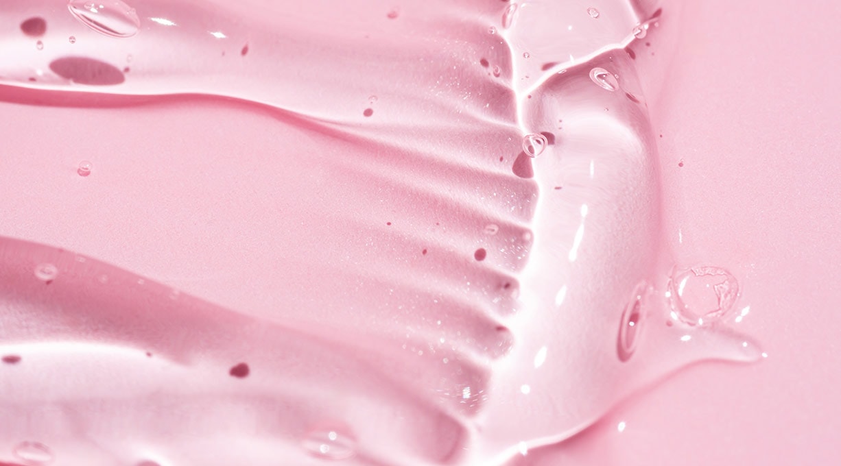 Rosa Geltextur mit feuchtem Glanz, Nahaufnahme einer Pflegeformel