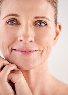 Frau mit glatter Haut lächelt sanft, Symbol für wirksame Anti-Aging-Pflege.