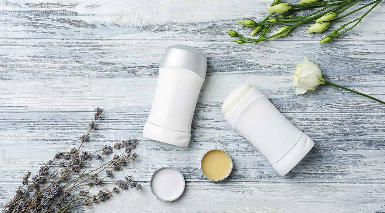 Deo-Sticks und Naturkosmetik mit Lavendel und Blüten, Hinweis auf aluminiumfreie Pflege.