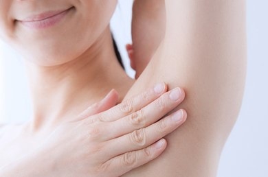 Eine Frau berührt ihre Achsel