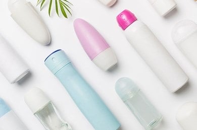 Auswahl verschiedener Deoarten – Roll-ons, Sprays und Sticks – auf weißem Tisch arrangiert.