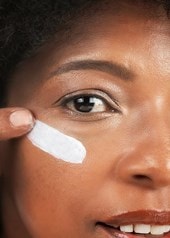 Frau trägt Creme mit Hyaluron unter dem Auge auf