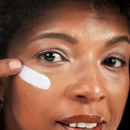 Frau trägt Creme mit Hyaluron unter dem Auge auf