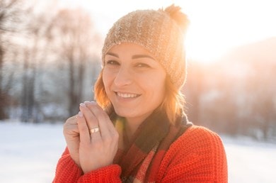 Frau im Winter mit warmer Kleidung, trockene Luft verursacht dehydrierte Gesichtshaut
