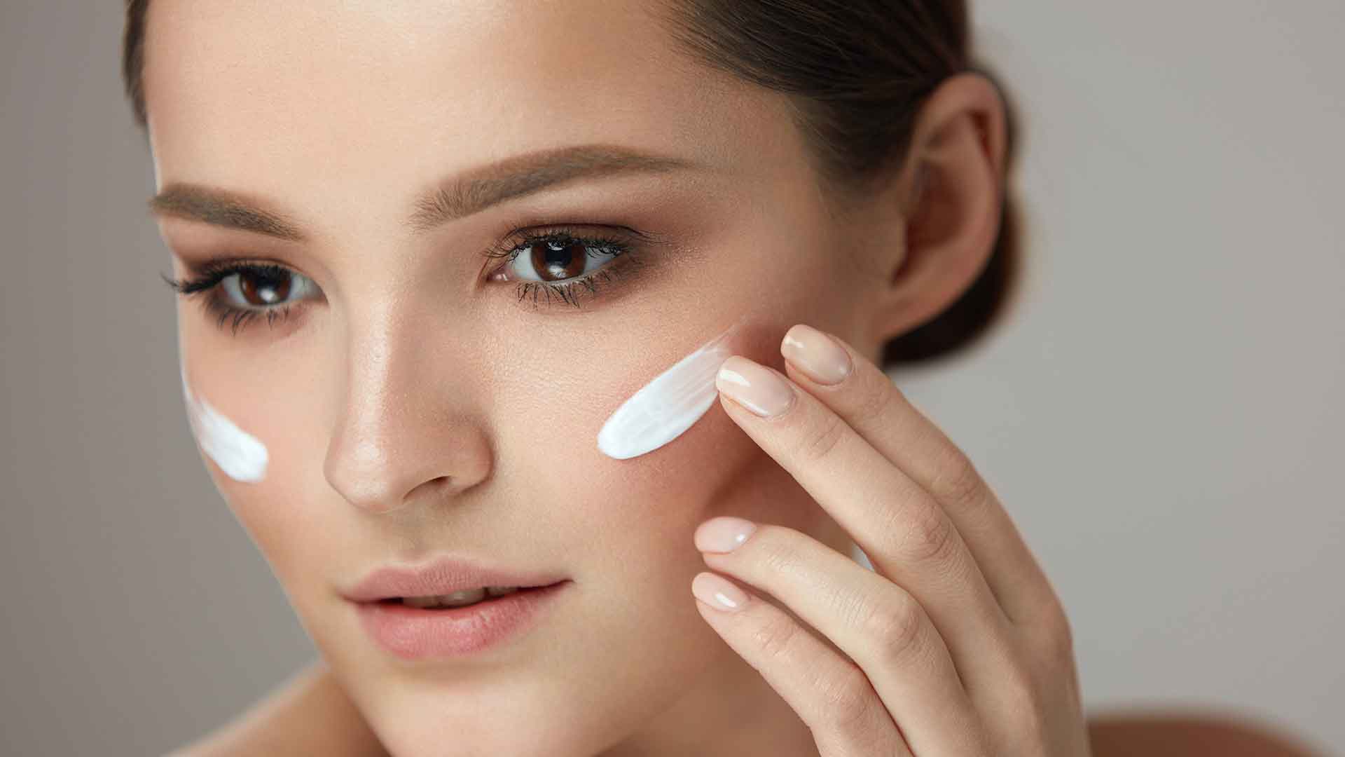 Frau trägt Creme mit Hyaluron auf ihr Gesicht auf