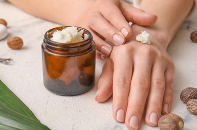 Nahaufnahme von Hände tragen pflegende Sheabutter auf, natürliche Feuchtigkeitspflege für trockene Haut
