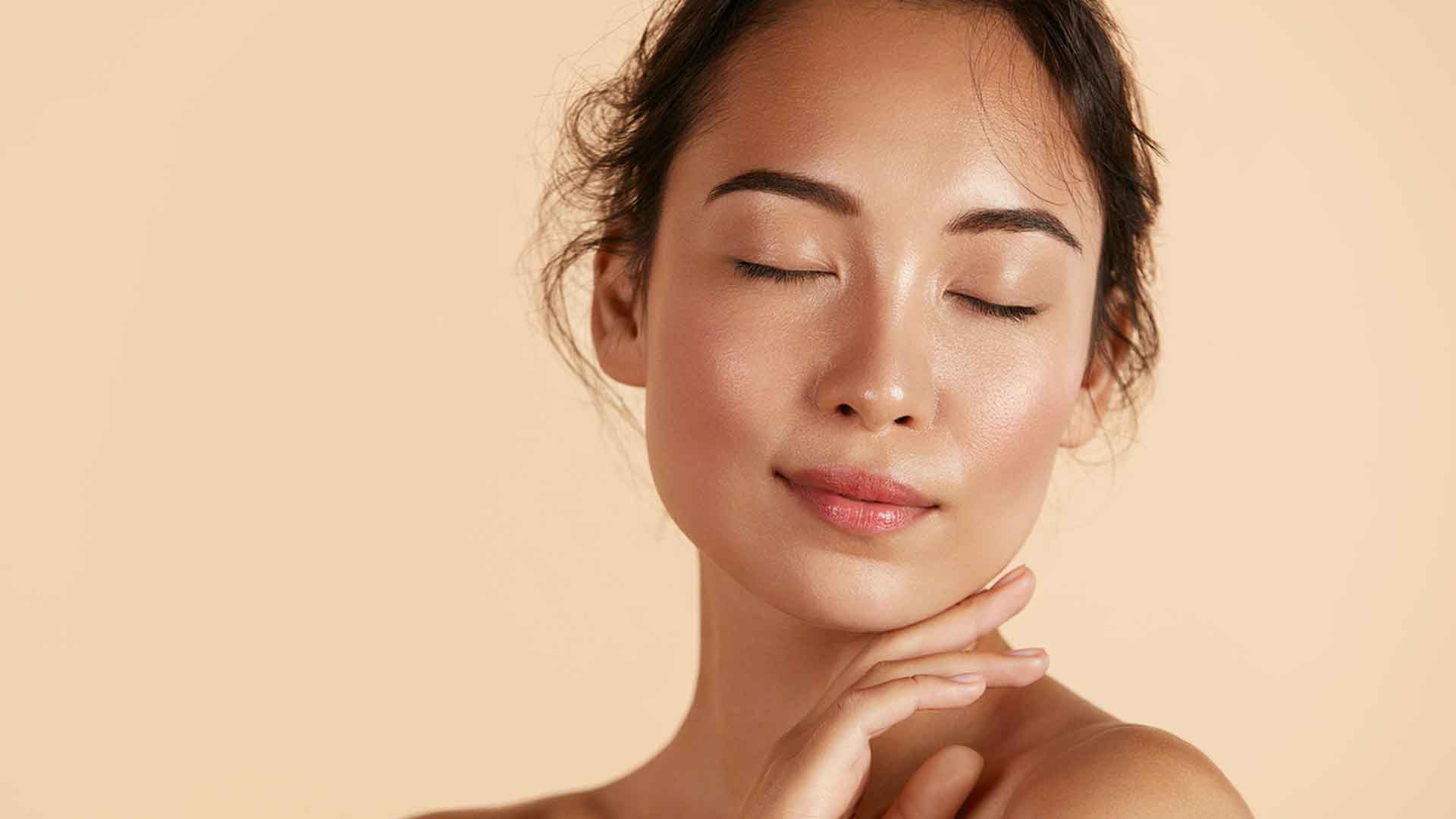 Frau mit geschlossenen Augen und strahlender Haut, steht für gesunde Feuchtigkeit und natürliche Pflege