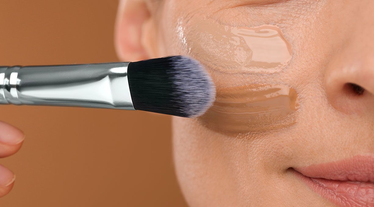 Make-up-Pinsel trägt leichte Foundation auf Wange auf, natürliche Deckkraft für ebenmässigen Teint