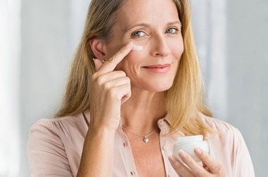 Frau mittleren Alters hält Creme