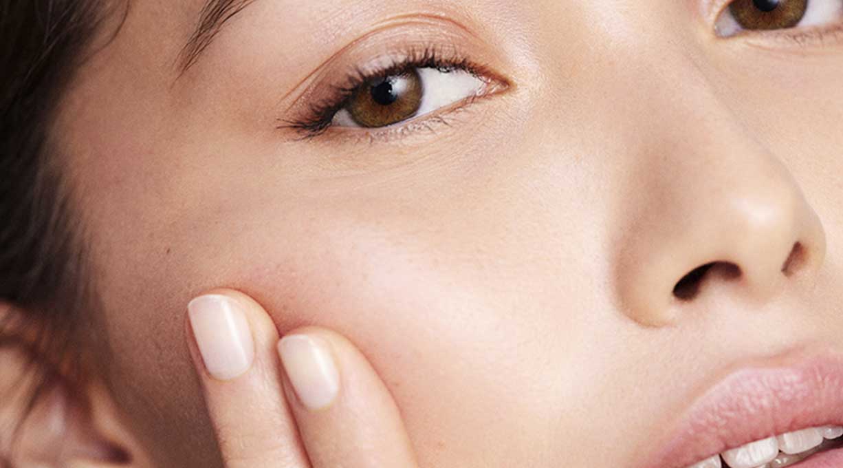 Nahaufnahme des Gesichts einer gepflegten Frau mit braunen Augen