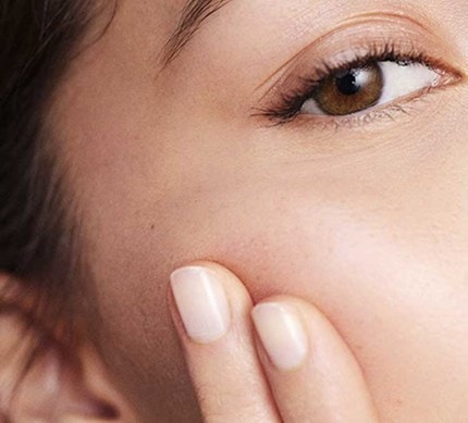 Nahaufnahme des Gesichts einer gepflegten Frau mit braunen Augen