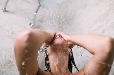 Frau genießt eine Dusche mit klarem Wasser
