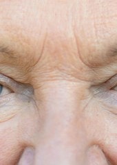 Nahaufnahme der Augenpartie einer älteren Frau mit sichtbaren Falten