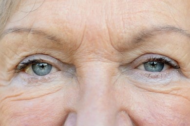 Nahaufnahme der Augenpartie einer älteren Frau mit sichtbaren Falten