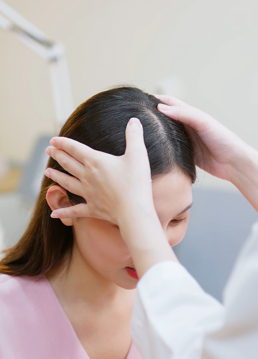Ärztin untersucht die Kopfhaut einer Patientin wegen Alopezie