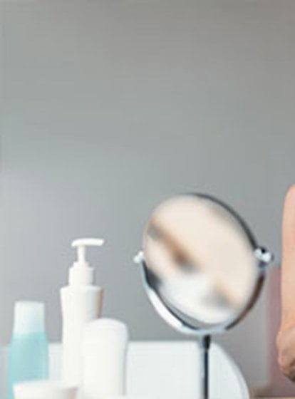 Ältere Frau hält eine Haarbürste und prüft ihre Haare nach dem Bürsten