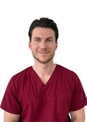 Dr. Rouben Czwikla im dunkelroten Arztkittel