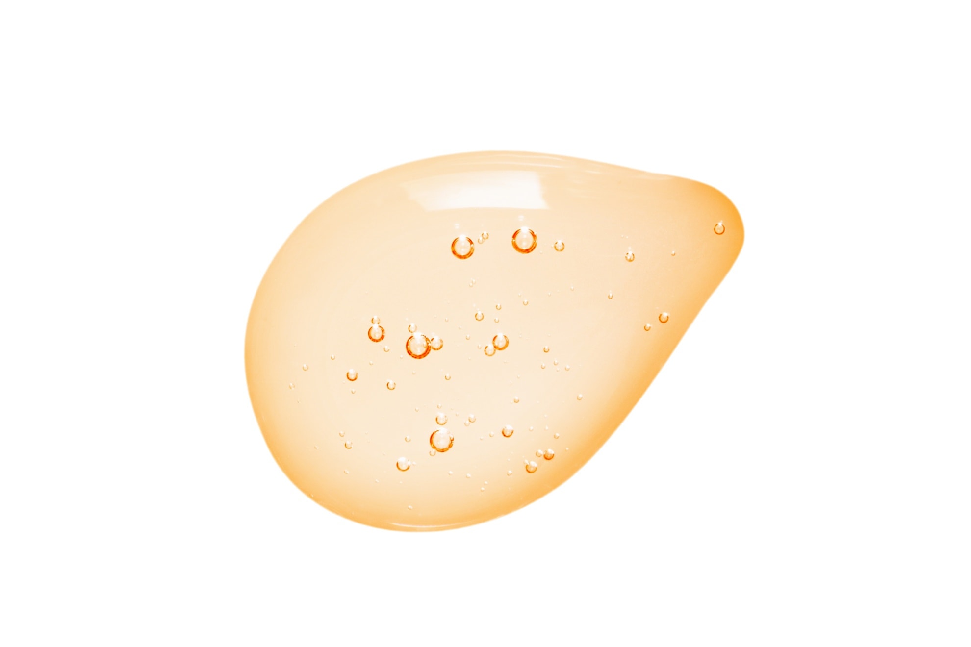 Tropfen einer gelb-orangefarbenen Flüssigkeit mit kleinen Bläschen