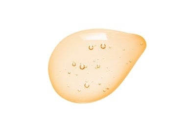 Tropfen einer gelb-orangefarbenen Flüssigkeit mit kleinen Bläschen