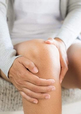 Person hält ihr Knie fest