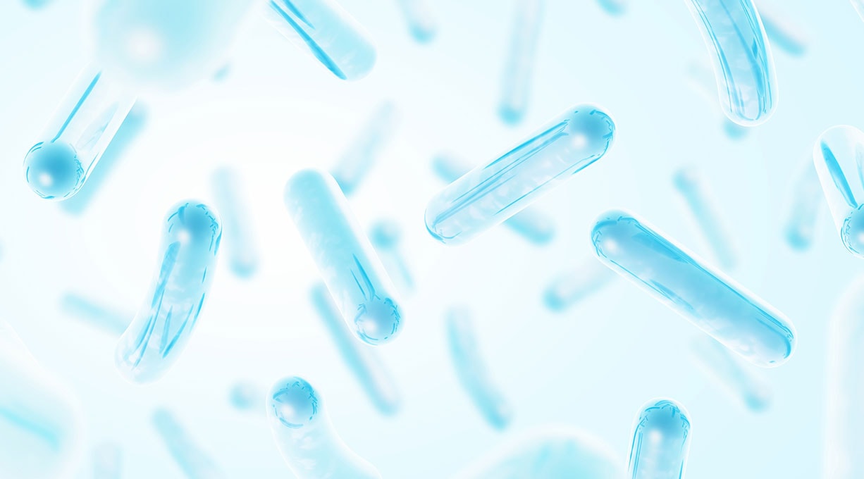 Ein Paar Hände mit weißen Handschuhen hält eine Pipette in eine Petrischale