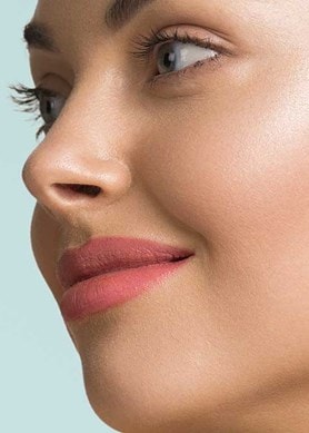 Junge, gepflegte Haut mit roséfarbenem Lippenstift von der Seite