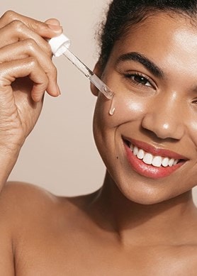 Junge Frau benutzt Serum im Gesicht