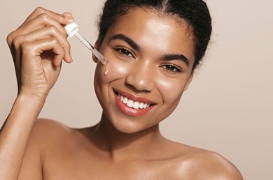 Junge Frau benutzt Serum im Gesicht