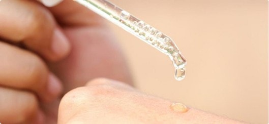 Serum wird mit einer Pipette auf die Haut getropft.