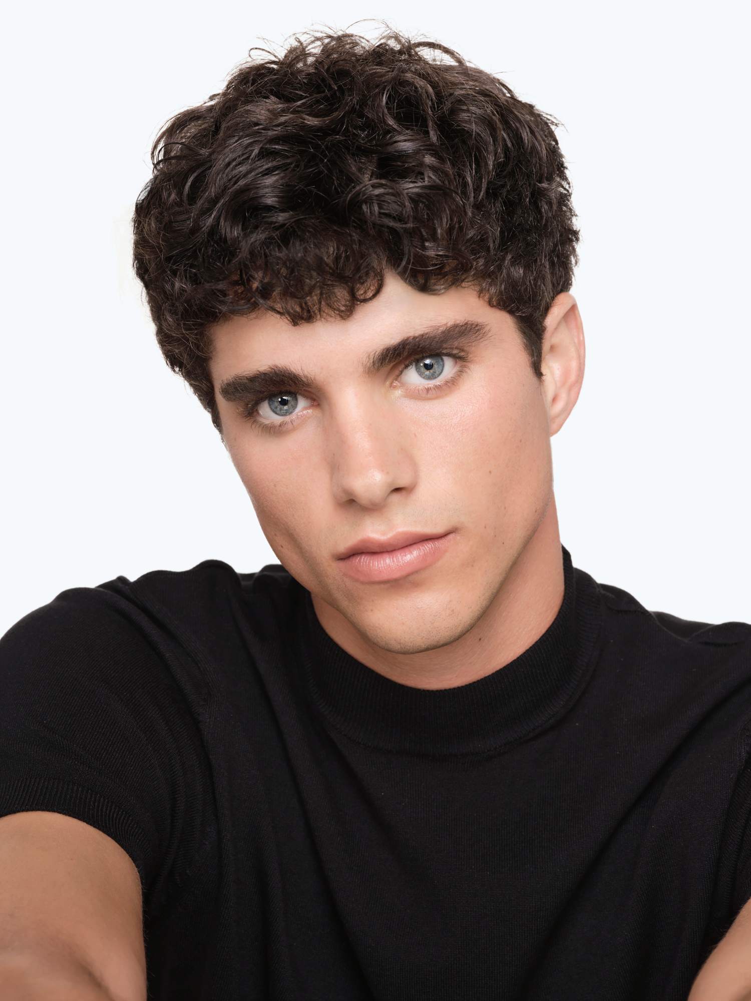 Junger Mann mit lockigen braunen Haaren