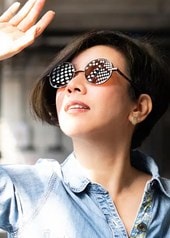 Eine Frau mit Sonnenbrille schaut Richtung Sonne