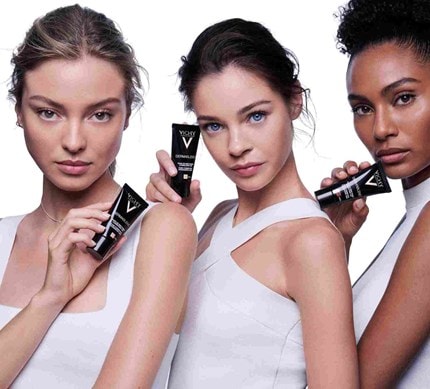 Drei Frauen mit verschiedenen Teints halten die Vichy Dermablend Foundation in der Hand.