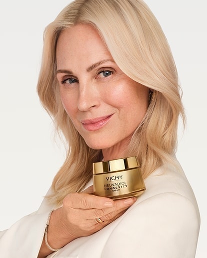 Blonde Frau hält einen goldenen Tiegel Vichy NEOVADIOL Longevity Cream