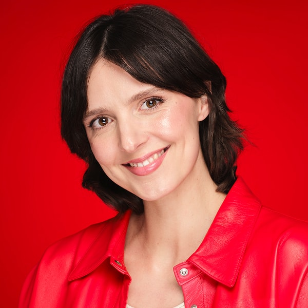 Portrait eines braunen Models mit einer roten Bluse und gepflegter Haut im Gesicht