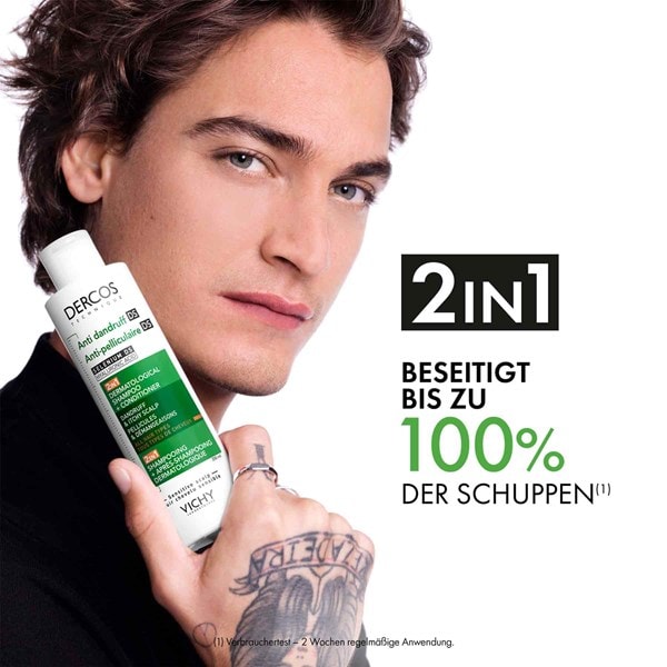 Junger Mann zeigt das Vichy Dercos 2 in1 anti-Schuppen Shampoo welches bis zu 100 % der Schuppen beseitigt.