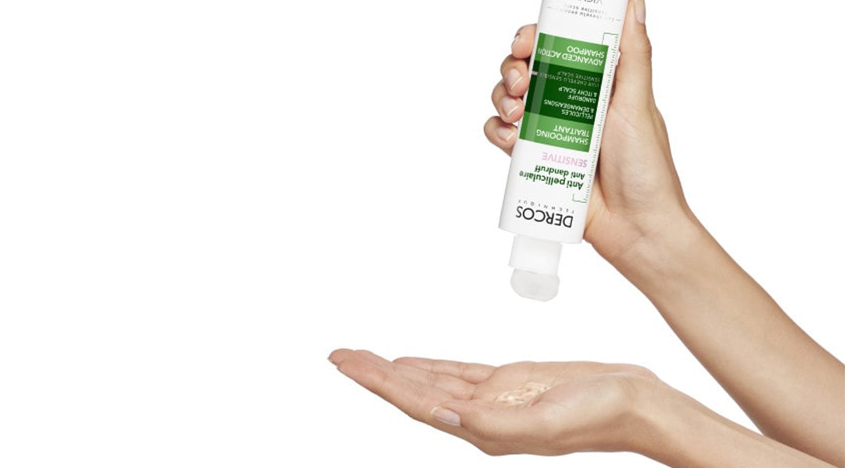 Person gibt DERCOS Anti-Schuppen Shampoo auf die Handinnenfläche