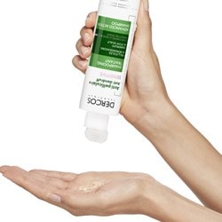 Person gibt DERCOS Anti-Schuppen Shampoo auf die Handinnenfläche