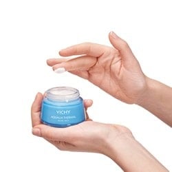 Person mit einem Klecks AQUALIA THERMAL Creme auf dem Mittelfinger