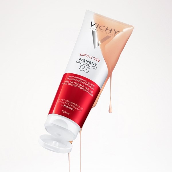 Geöffnete Tube Vichy Liftactiv Pigment Specialist B3 Peeling-Reinigungsgel, aus der beigefarbene Gel-Textur herabläuft